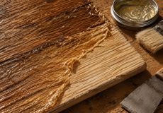 وارنیش قدیمی نرم‌شده در حال جدا شدن از الیاف چوب